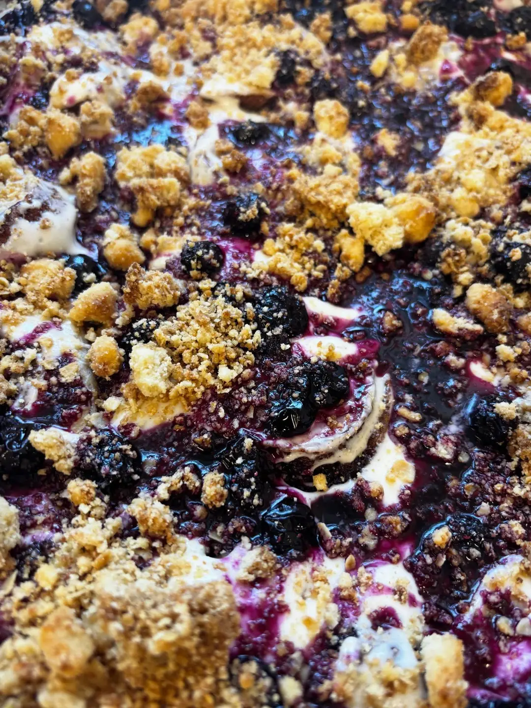 A close-up berry and crumble-topped bake